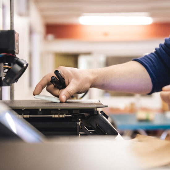 Photo d'une imprimante 3D en gros plan pour illustrer le travail de l'atelier.