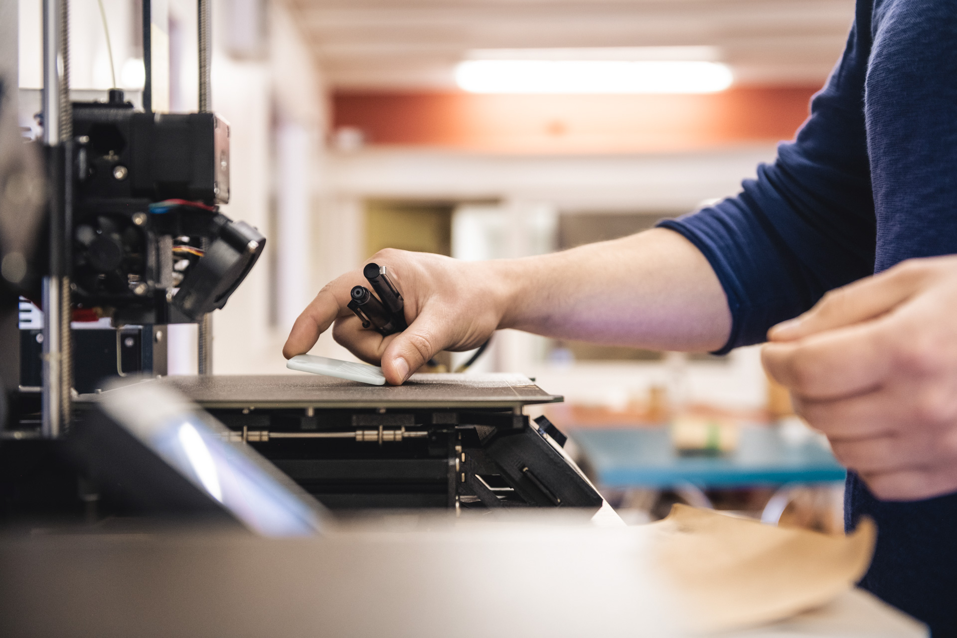 Photo d'une imprimante 3D en gros plan pour illustrer le travail de l'atelier.