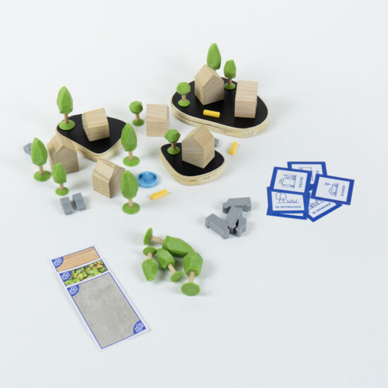 Maquette ludique d'urbanisme composée de maisons en bois, d'arbres imprimés en 3D et de cartes pour identifier et placer des usages.